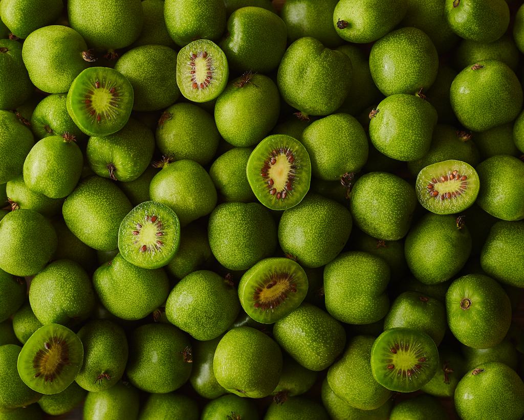 Kiwiberry pile with cut berries